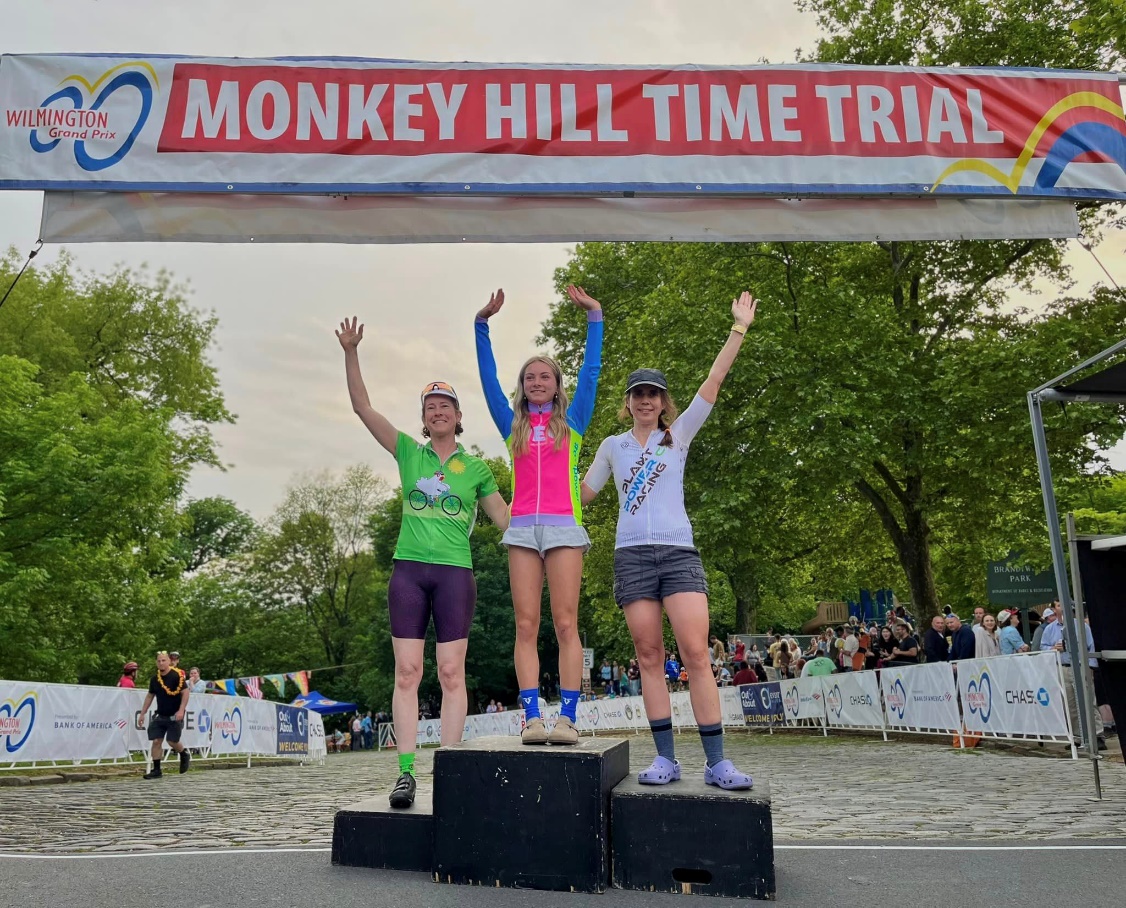 A group of people standing on podiums under a banner

Description automatically generated